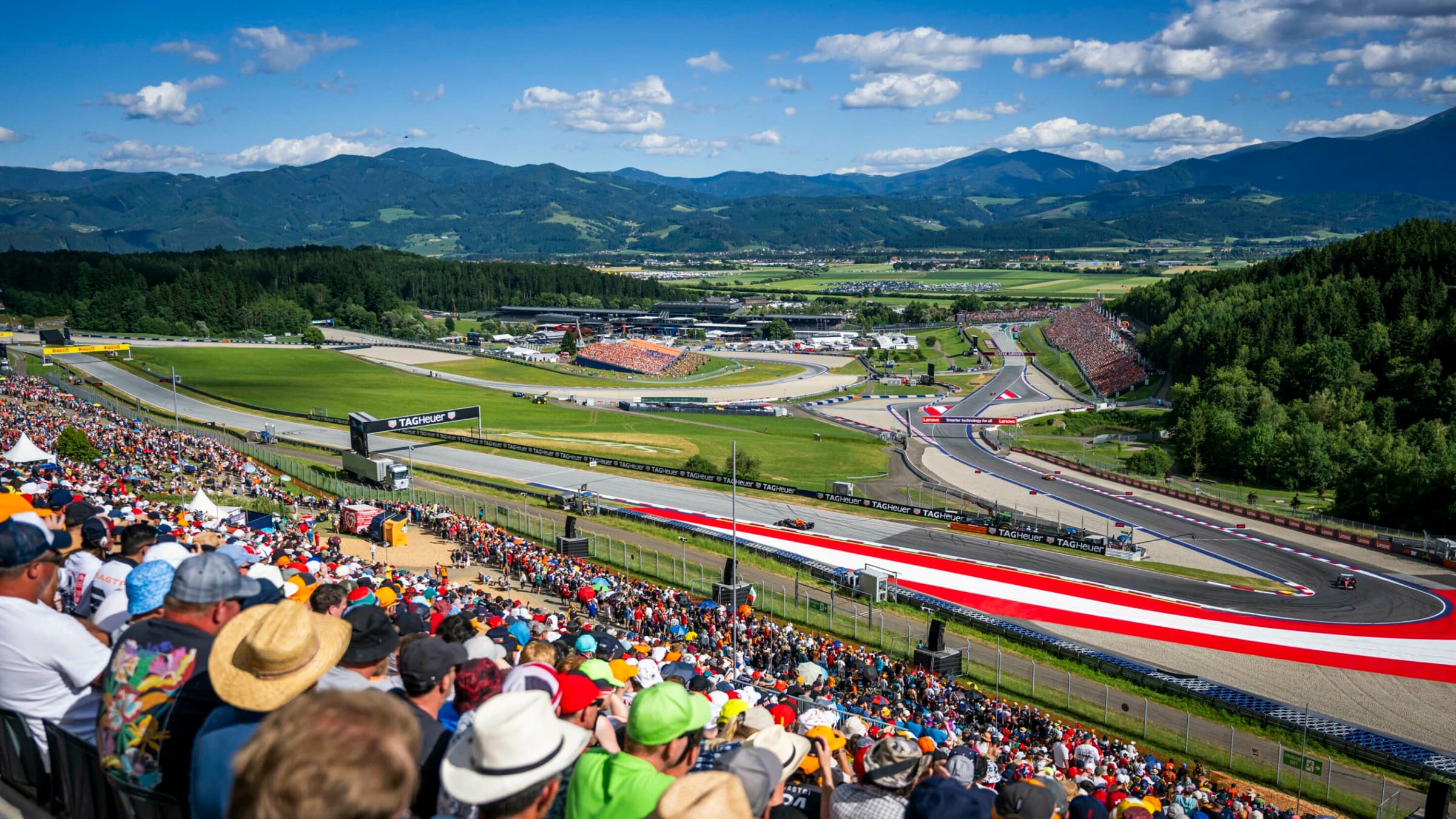 Blick über das vollbesetzte Red Bull Ring-Gelände: Tribünen, Strecke und Region an einem Rennwochenende